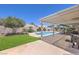 Inviting backyard pool with a covered patio, lush lawn and mature trees, creating a private outdoor oasis at 2738 Sandalwood Ave, Henderson, NV 89074