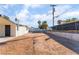 Large backyard with dry landscaping, a retaining wall, and chain link fence and palm trees in background at 2878 El Cajon St, Las Vegas, NV 89169