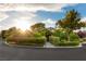 Daytime exterior elevation showcases verdant landscaping, mature trees, and a welcoming path to the front entrance at 3004 Astoria Pines Cir, Las Vegas, NV 89107