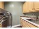 Laundry room featuring a modern washer and dryer, quartz countertops, and built-in cabinetry at 3004 Astoria Pines Cir, Las Vegas, NV 89107