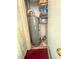 Water heater inside closet with dark red floors and shelving at 3101 Casey Dr # 204, Las Vegas, NV 89120
