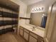 Well-lit bathroom featuring a vanity with cabinets, framed mirror, and shower with a striped curtain at 3550 Bay Sands Dr # 2070, Laughlin, NV 89029
