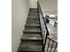Stairway with gray wood-look floors and a black metal railing leading to a modern kitchen at 3681 Melonies Dr # 29, Las Vegas, NV 89103