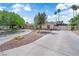 Charming single-story home with a circular driveway, mature trees, and secure gated entrance at 3753 Meadowcrest Dr, Las Vegas, NV 89121