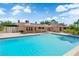 Backyard swimming pool with pristine water, surrounded by a patio and lush landscaping under a bright sky at 3753 Meadowcrest Dr, Las Vegas, NV 89121