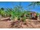 Desert backyard featuring trees, bushes, red rock landscaping, and a view of the back of the house at 4174 Cascada Piazza Ln, Las Vegas, NV 89135
