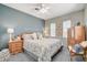 Comfortable bedroom with a queen bed with a floral pattern, wood furniture, and a ceiling fan with lights at 4174 Cascada Piazza Ln, Las Vegas, NV 89135