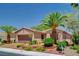 Single story stucco home with a two-car garage, professional landscaping and palm trees at 4174 Cascada Piazza Ln, Las Vegas, NV 89135