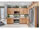 Well-lit kitchen with stainless steel refrigerator and lots of wooden cabinets for optimal storage at 4174 Cascada Piazza Ln, Las Vegas, NV 89135