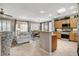 Open-concept living space featuring a kitchen with wood cabinets, a dining area, and a cozy sitting area at 4174 Cascada Piazza Ln, Las Vegas, NV 89135