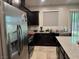Well-equipped kitchen features stainless steel appliances, dark cabinetry, and stone countertops at 4337 Stardusk Falls Ave, North Las Vegas, NV 89084