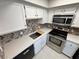 Modern kitchen with white cabinetry, stainless steel appliances, and mosaic backsplash at 435 Mesa Blvd # 202, Mesquite, NV 89027