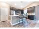 Modern kitchen features stainless steel appliances, dark cabinets, and a breakfast bar with bar stools at 4376 Latitude Valley Ct, North Las Vegas, NV 89084