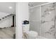 Updated bathroom with a glass-enclosed shower featuring marbled tile, a sleek toilet, and modern fixtures at 4490 W Warm Springs Rd, Las Vegas, NV 89118