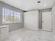 An organized bedroom featuring ample closet space, window with blinds, and marble floors at 4490 W Warm Springs Rd, Las Vegas, NV 89118