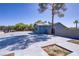 Home exterior featuring generous parking, secure fencing, and mature landscaping at 4490 W Warm Springs Rd, Las Vegas, NV 89118