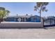 Charming home featuring secure fencing, mature trees, solar panels, and large windows at 4490 W Warm Springs Rd, Las Vegas, NV 89118