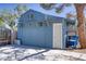 A detached blue garage with a carriage door, side entry, and exterior lighting, offering ample storage at 4490 W Warm Springs Rd, Las Vegas, NV 89118