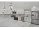 Modern kitchen with white cabinets, stainless steel appliances, and a waterfall edge island at 4490 W Warm Springs Rd, Las Vegas, NV 89118