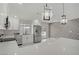 Modern kitchen features white cabinets, stainless steel appliances, and a bright, open floor plan at 4490 W Warm Springs Rd, Las Vegas, NV 89118