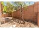 Private backyard with brick wall, desert landscaping, and shady trees at 455 Westminster Hall Ave # 101, North Las Vegas, NV 89032