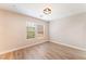 Bright bedroom featuring wood-look flooring and natural light from two windows at 455 Westminster Hall Ave # 101, North Las Vegas, NV 89032
