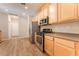 Bright kitchen features stainless steel appliances, wood cabinets and modern recessed lighting at 455 Westminster Hall Ave # 101, North Las Vegas, NV 89032