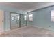 Bright bedroom featuring a mirrored closet, three windows, and carpet flooring at 4742 Obannon Dr # A, Las Vegas, NV 89102