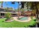 Landscaped backyard with pool, lush lawn, covered patio, and mature trees at 5260 N Jones Blvd, Las Vegas, NV 89130