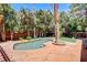 Backyard featuring a pool, string lights, landscaping, mature palms, and a grassy area at 5260 N Jones Blvd, Las Vegas, NV 89130