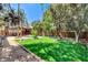 Expansive backyard with lush lawn, mature trees, a pool, and covered patio area at 5260 N Jones Blvd, Las Vegas, NV 89130