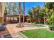 Backyard with a pool, lush lawn, covered patio, and mature trees at 5260 N Jones Blvd, Las Vegas, NV 89130
