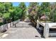 Gated driveway leading to a property surrounded by lush trees, topped with a waving American flag at 5260 N Jones Blvd, Las Vegas, NV 89130