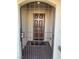 Front door with a security gate and a doormat that says HOME on a neutral tile floor at 5363 S Juneau St, Pahrump, NV 89061