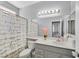 Bright bathroom featuring a shower with decorative curtain, white vanity, and ample lighting at 5923 Halehaven Dr, Las Vegas, NV 89110