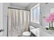 Bright bathroom featuring a shower with curtain, white vanity with ample storage and bright lighting at 5923 Halehaven Dr, Las Vegas, NV 89110