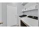Functional laundry room with modern washer and dryer, storage shelf, and utility door at 5923 Halehaven Dr, Las Vegas, NV 89110