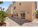 Home's exterior featuring a private patio with stone pavers, greenery, and multiple windows providing natural light at 6014 Belvedere Canyon Ave, Las Vegas, NV 89139
