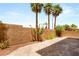 Outdoor patio features custom stone pavers, privacy wall, and flourishing plants and palm trees at 6014 Belvedere Canyon Ave, Las Vegas, NV 89139