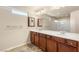 Bright bathroom features a double sink vanity with updated fixtures, and a large mirror at 6014 Belvedere Canyon Ave, Las Vegas, NV 89139