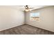 Bright bedroom features a ceiling fan, plush carpet, and a large window with a view of the neighborhood at 6014 Belvedere Canyon Ave, Las Vegas, NV 89139