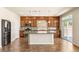 A spacious kitchen with an island, wooden cabinets, stainless appliances, and sliding doors at 6014 Belvedere Canyon Ave, Las Vegas, NV 89139