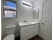 Bright bathroom featuring white cabinetry, modern fixtures, and a white countertop at 6063 Peach Orchard Rd, Las Vegas, NV 89142