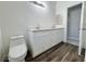 Bright bathroom featuring a double vanity with white cabinetry, modern fixtures, and wood-look flooring at 6063 Peach Orchard Rd, Las Vegas, NV 89142