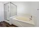 Bathroom showcasing a corner tub with tiled surround and glass shower doors at 6063 Peach Orchard Rd, Las Vegas, NV 89142