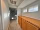 Upstairs hallway featuring carpet flooring, storage cabinet, three windows, and neutral paint at 6063 Peach Orchard Rd, Las Vegas, NV 89142