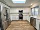 Updated kitchen featuring stainless steel appliances, modern white cabinetry, quartz countertops, and a skylight at 6063 Peach Orchard Rd, Las Vegas, NV 89142