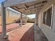 Spacious covered patio with brick flooring, access to a storage shed, and a view of the fenced backyard at 6063 Peach Orchard Rd, Las Vegas, NV 89142