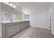 Bathroom featuring a double vanity with gray cabinets, white countertops, and wood look floors at 629 Soaring Wings Ave, Las Vegas, NV 89183