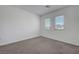 Bedroom with neutral carpet, white walls, and two windows for plenty of natural light at 629 Soaring Wings Ave, Las Vegas, NV 89183